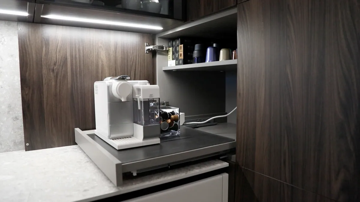 Concealed coffee station in KITWOOD’s completed DV kitchen, with a pull-out shelf, internal storage and a wood-grain cabinet door